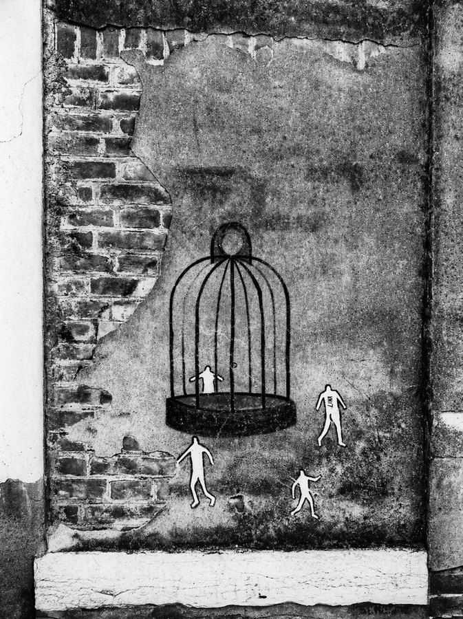 Black-and-white mixed-media scene of a weathered wall with a hanging birdcage drawing and small human figures beneath it.
